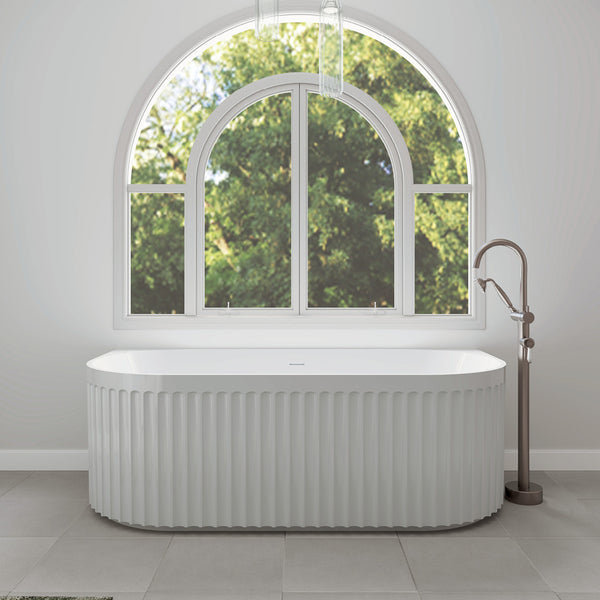 White freestanding acrylic bathtub in modern bathroom with large arched window