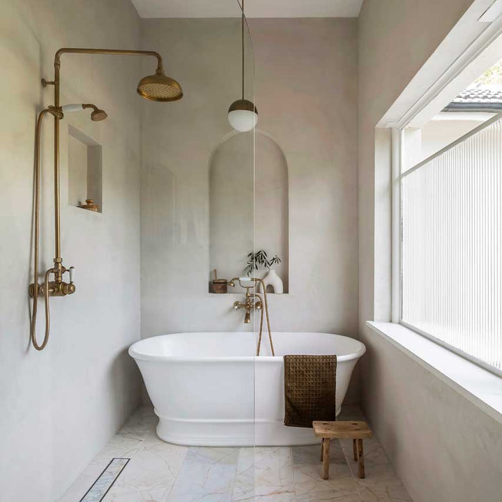 Modern bathroom with freestanding bathtub, shower system, and large window.