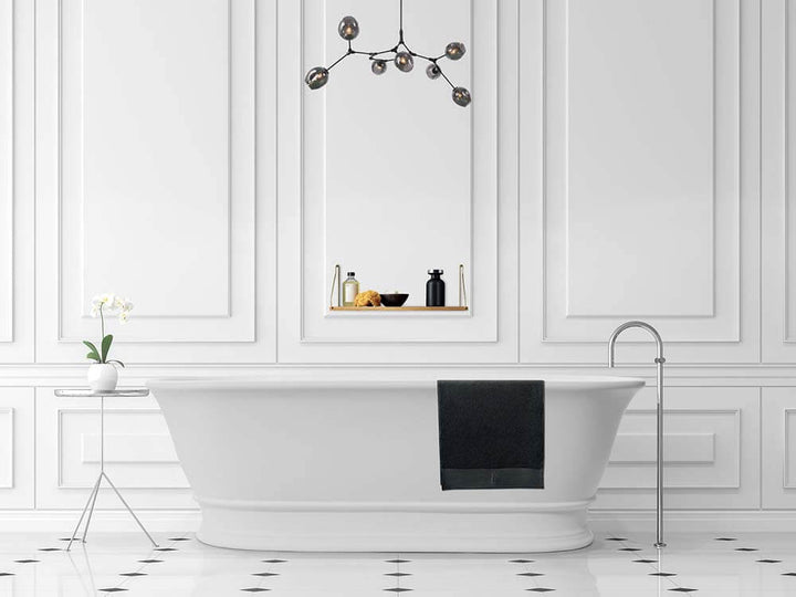 Modern bathroom with a freestanding bathtub, decorative wall mirror, and stylish lighting fixture.
